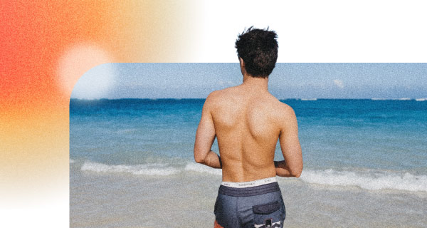 An image of a man on the beach, looking out over the ocean.