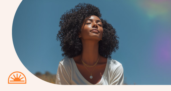 A woman outside meditating in the sun.